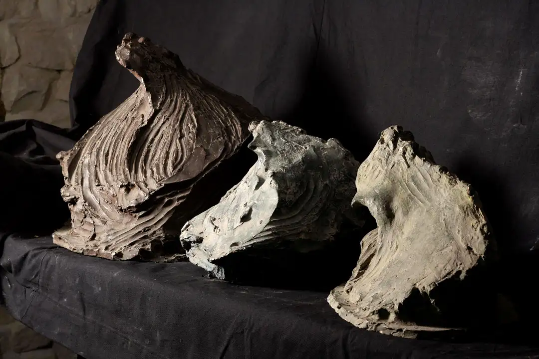 Three figurative sculptures placed in a row