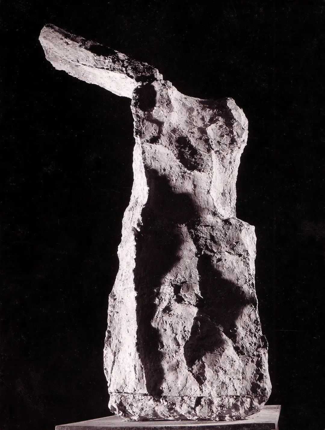 Figurative sculpture shot in black and white against a black background