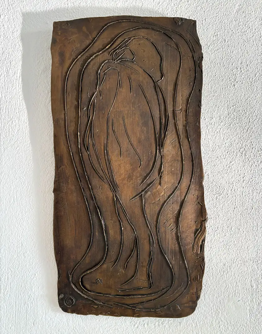 An abstract relief of a standing figure cast in bronze